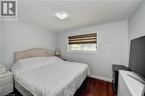 Bright bedroom featuring rich wood-finish flooring and a neutral color palette - 158 Plymouth Road, Kitchener, ON 