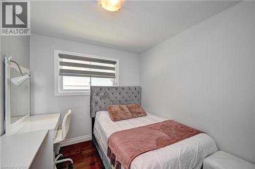 Bright room featuring a window with layered shades, overhead dome lighting, wood-finish flooring, and light gray painted walls - 158 Plymouth Road, Kitchener, ON 