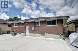 Brick exterior with a white rear entry door, featuring a concrete patio area - 