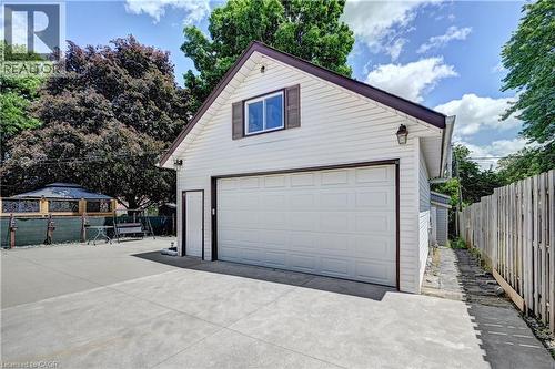 Detached garage featuring white siding, a single overhead door, and an upper-level window with shutters - 158 Plymouth Road, Kitchener, ON 