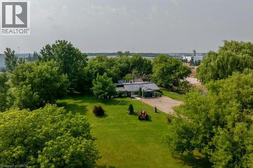 Sprawling grounds featuring a gravel driveway, mature trees, manicured lawns, and a single-story residence with a dark-pitched roof - 1264 Parkinson Road, Woodstock, ON 
