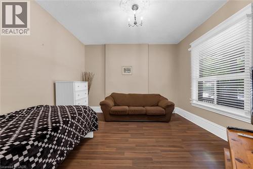 Room featuring wood-finish flooring, neutral wall tones, and white baseboards - 205 Ferguson Avenue S, Hamilton, ON - Indoor