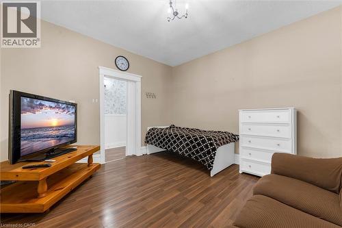 Warm-toned wood-finish flooring complements the neutral wall color - 205 Ferguson Avenue S, Hamilton, ON - Indoor Photo Showing Bedroom