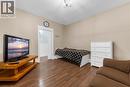 Warm-toned wood-finish flooring complements the neutral wall color - 205 Ferguson Avenue S, Hamilton, ON  - Indoor Photo Showing Bedroom 