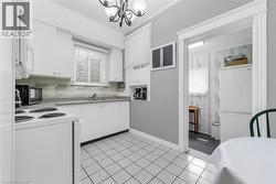 Well-appointed kitchen featuring white cabinetry, a light-toned backsplash, and a window above the sink - 