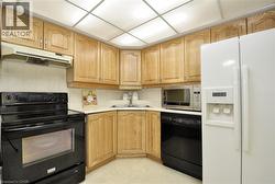 Efficient kitchen layout featuring wood cabinetry and white countertops - 