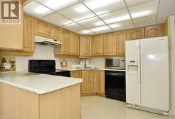Kitchen featuring wood cabinetry, white countertops, white tile backsplash, and a white side-by-side refrigerator - 
