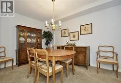 Dining area featuring a brass chandelier, neutral wall paint, and soft carpeting - 