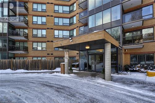 Building exterior featuring a brick facade and multiple balconies with glass railings - 237 King Street W Unit# 1305, Cambridge, ON - Outdoor