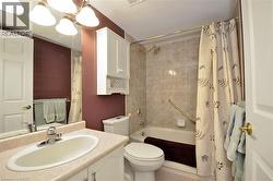 Bathroom featuring a light-colored vanity with an integrated sink, a full-width mirror, and a bath/shower combination with tiled surround - 