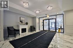 Building entrance featuring glass doors, paneled walls, and marble-look flooring - 