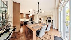 Open-concept main living area with wood-finish flooring throughout - 