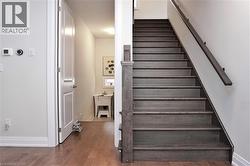 Staircase featuring dark wood-finish treads and risers, complemented by a matching wood-finish handrail and newel post - 