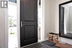 Entryway featuring a dark wood-finish paneled door, sidelite windows, and light-toned walls - 