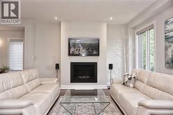 Living area featuring a floor-to-ceiling fireplace with a black surround, recessed lighting, a large window, and light-toned walls - 