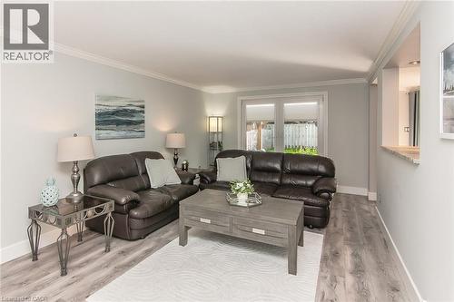 Spacious living area featuring light gray walls, crown molding, and wood-finish flooring - 529 Chesapeake Crescent, Waterloo, ON - Indoor Photo Showing Living Room