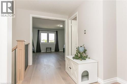 Upper-level hallway featuring light wood-finish flooring, white baseboards, and a contemporary wood and metal balustrade - 529 Chesapeake Crescent, Waterloo, ON - Indoor Photo Showing Other Room