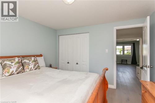 Bedroom featuring light blue walls, wood-finish flooring, and white bi-fold closet doors - 529 Chesapeake Crescent, Waterloo, ON - Indoor Photo Showing Bedroom