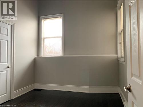 Unit 2 bedroom featuring light gray walls, dark wood-finish flooring, and white trim - 405 Macnab Street N, Hamilton, ON 