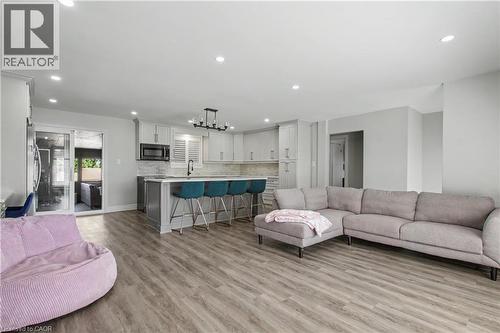 Open-concept living area featuring wood-finish flooring, recessed lighting, and a kitchen island with seating - 44 Oakhurst Crescent, Kitchener, ON - Indoor Photo Showing Living Room
