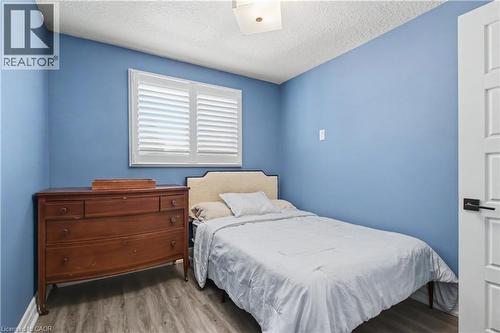 Room featuring blue walls, wood-finish flooring, and a white plantation-shutter window - 44 Oakhurst Crescent, Kitchener, ON - Indoor Photo Showing Bedroom
