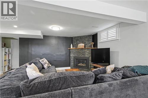 Living area featuring a floor-to-ceiling stacked stone fireplace with an integrated firebox and wood mantle - 44 Oakhurst Crescent, Kitchener, ON - Indoor With Fireplace