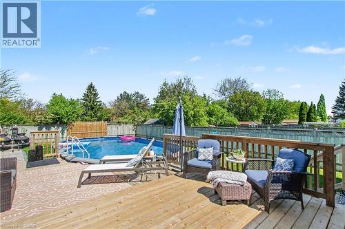 Expansive wood deck featuring a balustrade railing, providing access to an above-ground swimming pool with ladder entry - 44 Oakhurst Crescent, Kitchener, ON - Outdoor With Above Ground Pool With Deck Patio Veranda
