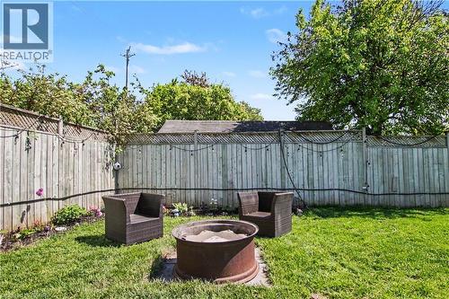 Fenced backyard featuring a lawn area, mature trees, and a fire pit - 44 Oakhurst Crescent, Kitchener, ON - Outdoor