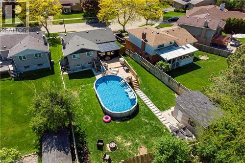 Expansive backyard featuring an oval above-ground pool with surrounding deck, a flagstone-style pathway, a detached storage shed, and a privacy fence - 44 Oakhurst Crescent, Kitchener, ON - Outdoor With Above Ground Pool
