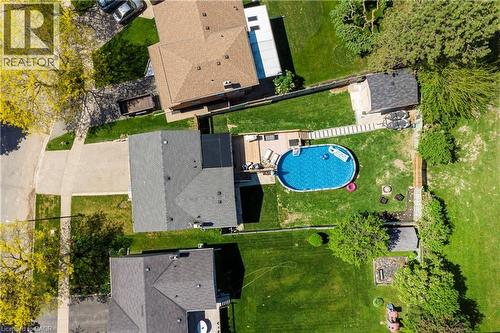 Expansive private backyard featuring a large oval swimming pool, a wooden deck, and a detached storage shed - 44 Oakhurst Crescent, Kitchener, ON - Outdoor With Above Ground Pool