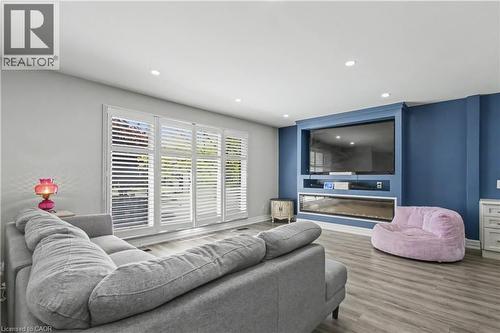 Living area featuring a custom built-in entertainment center, recessed lighting, and wood-finish flooring - 44 Oakhurst Crescent, Kitchener, ON - Indoor Photo Showing Living Room