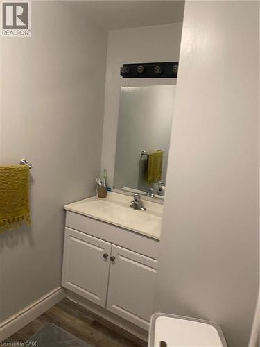 Half bathroom featuring vanity and wood finished floors - 58 Hazelglen Drive, Kitchener, ON - Indoor Photo Showing Bathroom