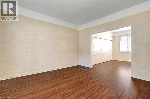 Warm wood-finish flooring complements the neutral textured wall coverings - 14 Niagara Street, Hamilton, ON 