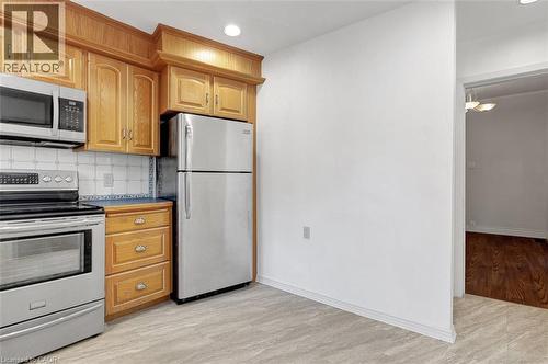 Kitchen area with light wood-finish cabinetry, stainless steel appliances, and a tiled backsplash - 14 Niagara Street, Hamilton, ON 