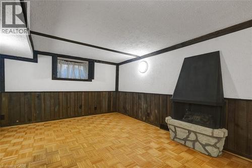 Room featuring a freestanding fireplace with a stone-finish hearth - 14 Niagara Street, Hamilton, ON 