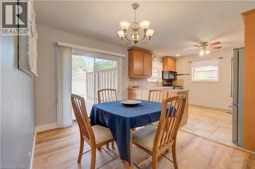 Dining area featuring wood-finish flooring, a contemporary chandelier, and direct access to an outdoor deck via sliding glass doors - 251 Union Street E, Waterloo, ON 