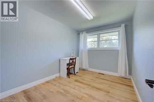 Bright room featuring light blue walls, wood-finish flooring, and white baseboards - 251 Union Street E, Waterloo, ON 
