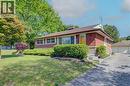 Brick exterior with stone accents, a deep brown shingle roof, a vibrant yellow front door, and a concrete driveway - 251 Union Street E, Waterloo, ON 