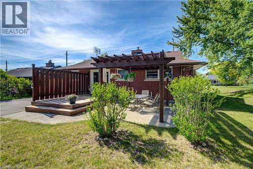 Rear elevation featuring a brick exterior and a tiered wood deck with privacy fencing - 251 Union Street E, Waterloo, ON 
