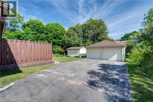 Two-car garage with multiple overhead doors, asphalt driveway, and a fenced yard - 251 Union Street E, Waterloo, ON 