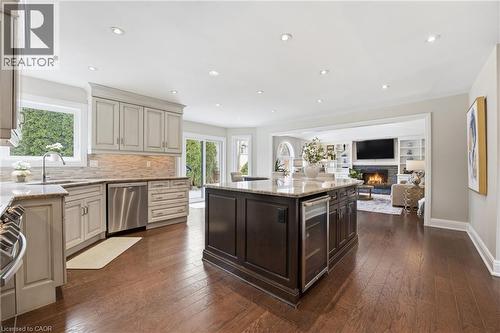 Kitchen featuring light stone counters, open floor plan, wine cooler, stainless steel appliances, and recessed lighting - 28 Deerview Avenue, Ancaster, ON 