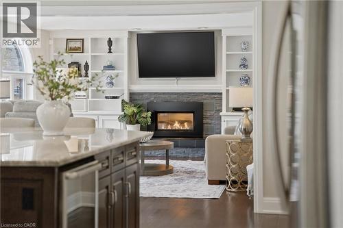 Living room with built in features, a fireplace, and dark wood-type flooring - 28 Deerview Avenue, Ancaster, ON 