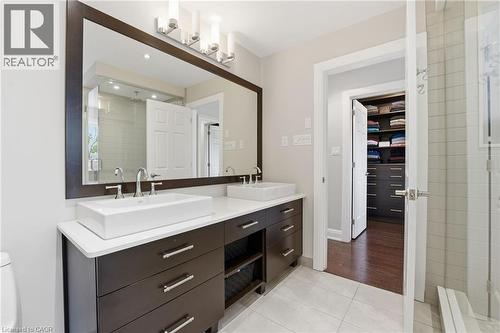 Bathroom with double vanity, light tile patterned flooring, and a stall shower - 28 Deerview Avenue, Ancaster, ON 