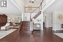 Staircase featuring a high ceiling, wood-type flooring, hanging lights, and crown molding - 28 Deerview Avenue, Ancaster, ON 