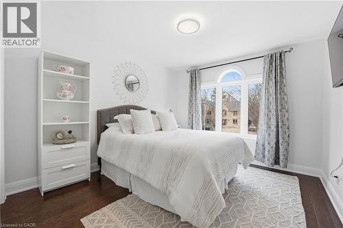 Bedroom with baseboards and dark wood-style floors - 28 Deerview Avenue, Ancaster, ON 