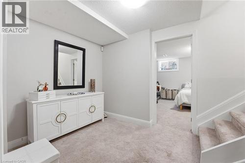 Bedroom featuring light colored carpet and a textured ceiling - 28 Deerview Avenue, Ancaster, ON 