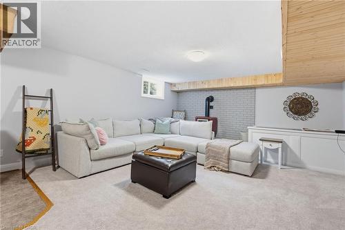 Living room with a wood stove and light colored carpet - 28 Deerview Avenue, Ancaster, ON 