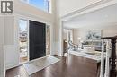 Entrance foyer with dark wood-style floors, a wainscoted wall, a decorative wall, and a high ceiling - 28 Deerview Avenue, Ancaster, ON 