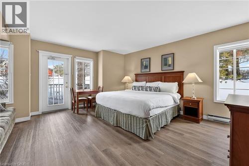 Bedroom with access to outside, wood finished floors, and a baseboard radiator - 90 Highland Drive Unit# 2014/15, Simcoe, ON 