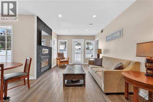 Living area with a stone fireplace, light wood-style flooring, and recessed lighting - 90 Highland Drive Unit# 2014/15, Simcoe, ON 